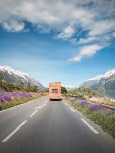 photo d'une tiny house sur une route avec des montagnes enneigées au loin