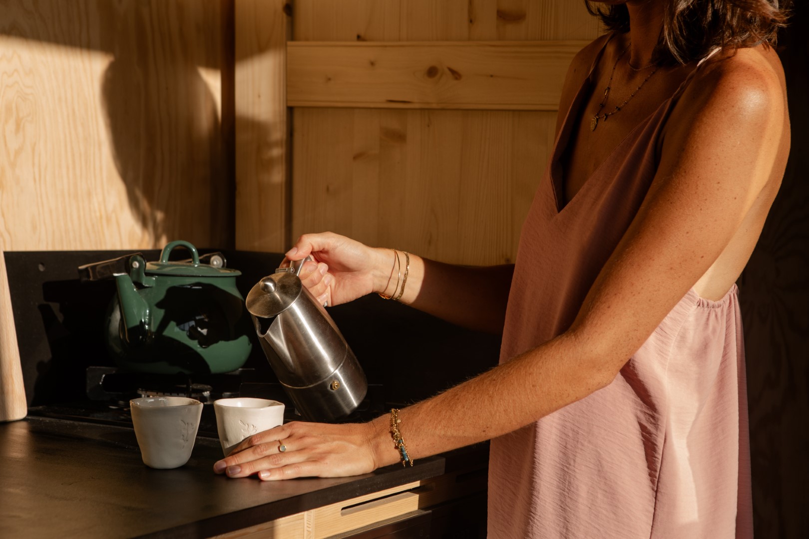 Une femme se sert un thé dans une tiny house